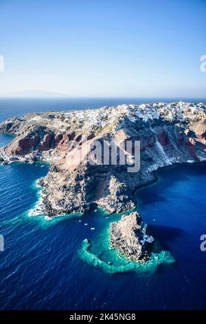 Luftaufnahme einer Insel im tiefblauen Meer der Ägäis, Felsformationen, weiß getünchte Häuser auf den Klippen. Stockfoto