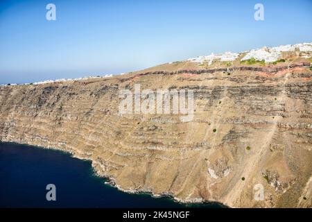 Luftaufnahme einer Stadt auf einer steilen Klippe auf der Insel Egeo, weiß getünchte Häuser auf der Klippe. Stockfoto