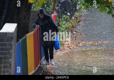 Eine Frau manövriert bei starken Regenfällen in Glasgow an einer riesigen Pfütze vorbei. Bilddatum: Freitag, 30. September 2022. Stockfoto