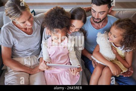 Großeltern, Eltern und Kinder elearning mit einem Tablet auf dem Sofa im Familienhaus. Kinder auf digitalen Gadget für Online-Lernen, Kinder-Websites und Stockfoto