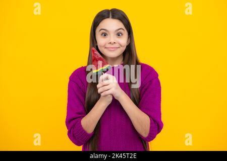 Hipster Teenager Kind Mädchen lecken Lollypop. Zucker Ernährung, Süßigkeiten und Süßigkeiten. Kind isst Lollipop-Popsicle. Stockfoto