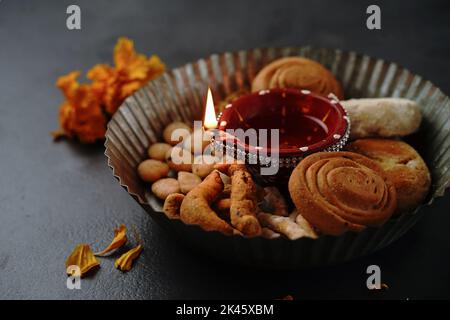 Diwali Snacks mit Diya Lampe beleuchtet - Deepavali Hintergrund, selektive Focu Stockfoto