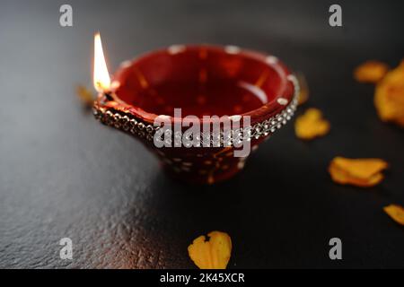 Happy Diwali Hintergrund - Bunte Clay Diya beleuchtet während Deepavali Festival auf schwarzem Hintergrund, Draufsicht Stockfoto