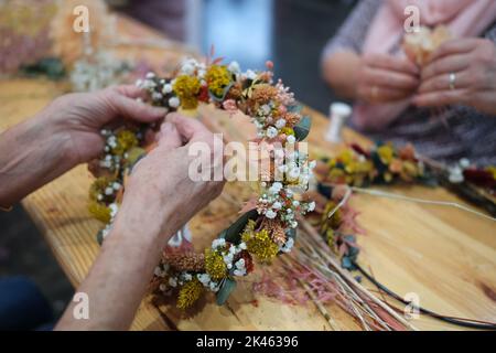 Leipzig, Deutschland. 30. September 2022. Besucher der Leipziger Messe 'Modell Hobby Spiel' arbeiten mit getrockneten Blumen. Vom 30,09. Bis 03.10.2022 zeigen 400 Aussteller, Vereine und Verbände Neues für Hobbyisten, Kreative und Spielebegeisterte. Quelle: Sebastian Willnow/dpa/ZB/dpa/Alamy Live News Stockfoto