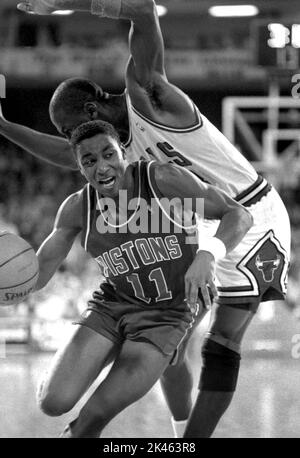 Der Detroit Piston Isiah Thomas fährt im Jahr 1980s in Spielaction am Verteidiger Michael Jordan der Chicago Bulls vorbei. Stockfoto