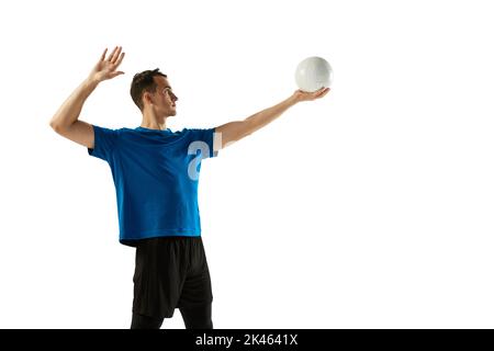 Dynamisches Porträt eines männlichen Volleyballspielers mit Ball isoliert auf weißem Studiohintergrund. Sport, Fitnessstudio, Teamsport, Herausforderungen Stockfoto