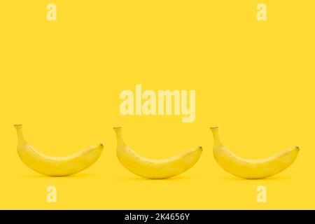 Drei Bananen auf gelbem Hintergrund mit Kopierraum Stockfoto