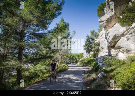 Radler auf einer ruhigen Landstraße in den Alpilles in der Nähe von Saint-Rémy-de-Provence, Frankreich. Stockfoto