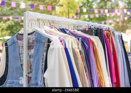 Lviv, Ukraine - September 29. 2022 : Vintage-Kleidung zum Verkauf auf dem Flohmarkt. Kleidung an Kleiderbügeln - Second Hand Bekleidungsgeschäft oder Sparsamkeit Shopping concep Stockfoto