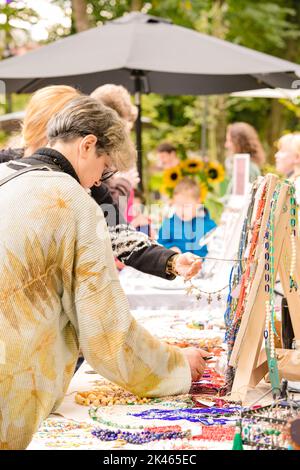 Lviv, Ukraine - September 29. 2022 : Leute, die auf dem Flohmarkt einkaufen. Vintage und handgemachte Nachahmung Schmuck zum Verkauf auf dem Sonntagsmarkt oder Souvenir-sta Stockfoto