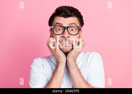 Nahaufnahme Foto von jungen funnny gut aussehend attraktiven bärtigen Mann beißen Finger Nägel nervös Gesicht tragen Brille Deadline Arbeitsmanager auf rosa isoliert Stockfoto