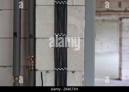 Rohre im Bau, sichtbare Wasserrohre in der Wand. Stockfoto