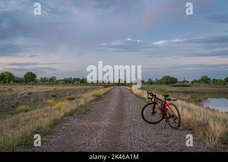 Schotterfahrrad mit Kopf- und Rückleuchten auf einer unbefestigten Straße in der Landschaft Colorados Stockfoto