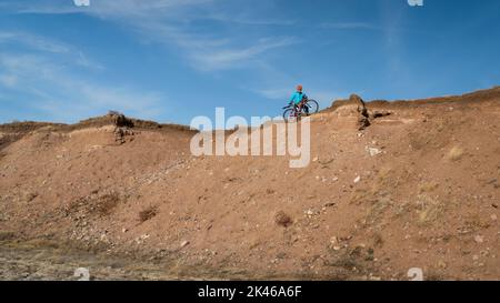 Ein Radler fährt auf einem Schotterfahrrad am Klippenrand in der Colorado Prairie - Naturgebiet Soapstone Prairie Stockfoto