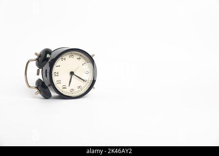 Schwarzer Vintage-Wecker isoliert auf weißem Hintergrund, Zeitkonzept, 9:35 Uhr. Morgen, Erinnerung. Stockfoto