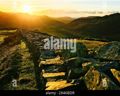 Britische Landschaft Berglandschaft bei Sonnenuntergang mit Ruinen römischer Gebäude Standort in Lake District, Großbritannien Stockfoto