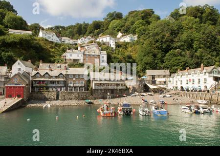 Clovelly. Blick auf das Dorf von der Hafenmauer zeigt das Red Lion Hotel, Meer, Boote und Ferienhäuser, Devon Küste, Tide in mit Booten, Crazy Kate's Stockfoto