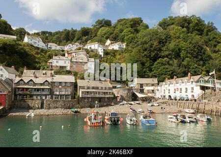 Clovelly. Blick auf das Dorf von der Hafenmauer zeigt das Red Lion Hotel, Meer, Boote und Ferienhäuser, Devon Küste, Tide in mit Booten, Crazy Kate's Stockfoto