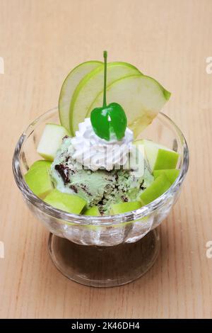 Schokoladen-Minze-Eis mit frischem Obst, klassisch dekoriert auf Holztisch zum Dessert Stockfoto