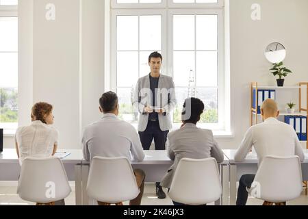 Mann Lehrer Couch lehrt kommuniziert mit einer Gruppe von erwachsenen Studenten während des Vortrags. Stockfoto