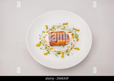 Gebratenen Lachs mit Passionsfrucht-Sauce und Sesbanblüte, isoliert auf weißem Hintergrund, Draufsicht Stockfoto