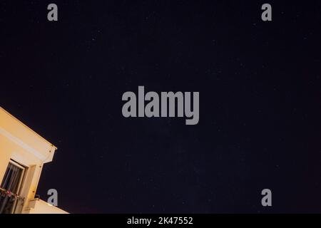 Himmel voller Sterne mit Galaxie und nebligen Wolken, die von der adriaküste Kroatiens über Häusern am Ufer sichtbar sind Stockfoto