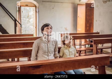 Christian Papa erzählt seinem Sohn biblische Geschichten über Jesus in kirk sitzen. Glaube, Religionsunterricht, moderne Kirche, Vatertag, väterliche Stockfoto