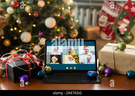Große Familie singt weihnachtslied auf Tablet-Kamera während Online-Videoanruf. Lächelnde Eltern und Kinder. Fröhliche Familie gratuliert Verwandten mit Stockfoto