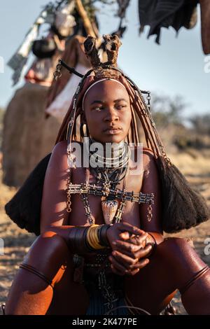 Junge Himba-Frau in Namibia, Afrika, in traditionellem Stil gekleidet. Stockfoto