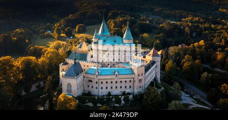 Bojnice, Slowakei - 26. September, 2022: Luftpanorama von Schloss Bojnice in der Slowakei, umgeben von Wald bei warmem Abendlicht Stockfoto