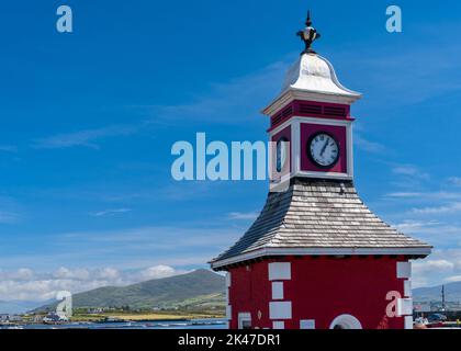 Knight's Town, Irland - 8. August 2022: Blick auf den historischen Uhrenturm und die Wiegestation am Royal Pier von Knight's Town auf Valentia Island in C Stockfoto