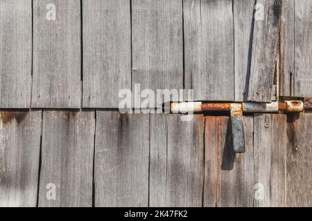 Rostiger Türriegel in alten, unlackierten Türen Stockfoto