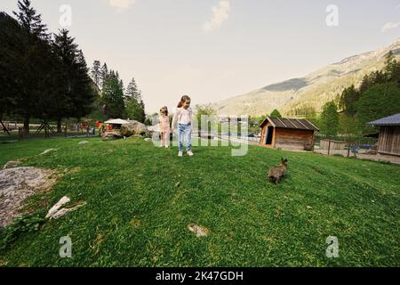 Schwestern spielen mit Kaninchen im Wildpark Untertauern, Österreich. Stockfoto