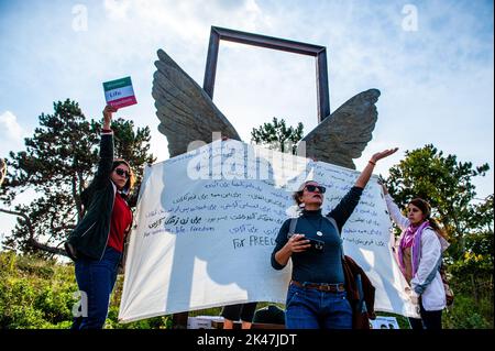 Iranische Frauen werden gesehen, wie sie während der Demonstration ein großes Banner mit einem Lied über die Freiheit halten. Das iranische Volk versammelte sich vor dem Internationalen Strafgerichtshof in Den Haag, um die Stimme des iranischen Volkes zu erheben und Gerechtigkeit für die systematischen Verbrechen und Gewalt zu fordern, die von den Behörden des islamischen Regimes gegen die Iraner begangen wurden. Die Proteste im Iran und in der ganzen Welt haben sich in dieser Woche verstärkt wegen des Todes der 22-jährigen Mahsa Amini in Polizeigewahrsam, nachdem sie verhaftet wurde, weil sie angeblich ihr Kopftuch zu locker getragen hatte. (Foto von Ana Fernandez / Stockfoto