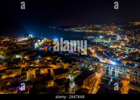 Luftaufnahme der Stadt Kavala in der Nacht, in Nordgriechenland, alten Aquädukt Kamares, Häuser und mittelalterliche Stadtmauer Stockfoto