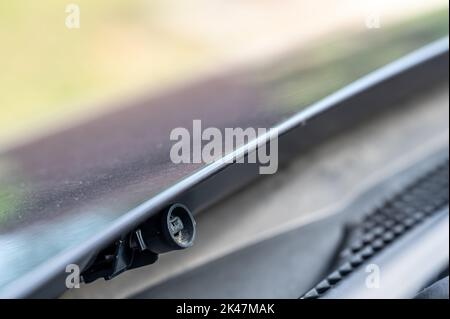 Scheibenwaschdüse unter der Motorhaube, mit der Flüssigkeit zum Reinigen von Glas auf ein Fahrzeug gesprüht wird. Stockfoto