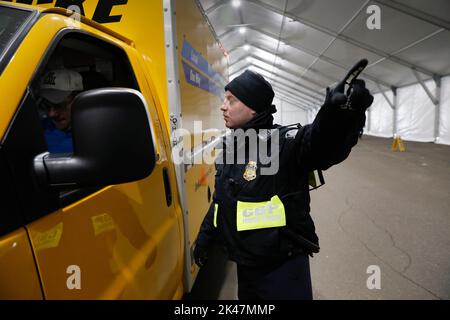 Einer US-amerikanischen Zoll- und Grenzschutzbehörden, Büro der Feldeinsätze, Offizier Gesten wie er lenkt der Fahrer eines Lkw, wo kurz vor dem Röntgen das Fahrzeug während Nicht-intrusive Inspektionen vor dem Super Bowl LII in Minneapolis, Minn., Jan. 30, 2018 zu stehen. Am Sonntag, 24.02.4, die Philadelphia Eagles wird gegen die New England Patriots für die NFL Meisterschaft. Us-amerikanischen Zoll- und Grenzschutzbehörden Foto von Glenn Fawcett Stockfoto