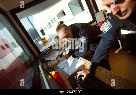 US-Zoll- und Grenzschutzbeamte überprüfen die Anmeldeinformationen des LKW-Fahrers und seiner Sendung, während er den US-Kontrollpunkt der Frachtvorinspektion im Hafen von Otay Mesa, Kalifornien, passiert, 23. Juni 2016. An jedem Tag stehen mehrere hundert Lastwagen auf der mexikanischen Seite der Grenze an, um importierte Produkte zu liefern, die auf die Überprüfung durch Zollbeamte warten. Eine wachsende Anzahl von Reedereien nutzt die Cargo Pre-Inspection von CBP, die vertrauenswürdigen Spediteuren eine schnellere und effizientere Möglichkeit bietet, Produkte an US-Einzelhändler zu liefern. CBP Foto von Glen Stockfoto