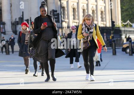 London, Großbritannien. 28. September 2022. Frauen sahen, wie sie ihre Handys betraten, während sie im Zentrum von London gingen. (Foto: Dinendra Haria/SOPA Images/Sipa USA) Quelle: SIPA USA/Alamy Live News Stockfoto