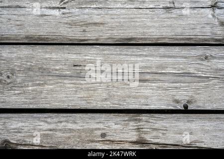 Holz Scheune Planken Hintergrund, alte rustikale Holzwand Nahaufnahme. Verwittertes, raues Holz mit Rissen, Maserung und Ästen, graue Vintage-Trockenbretter für die Wallpap Stockfoto
