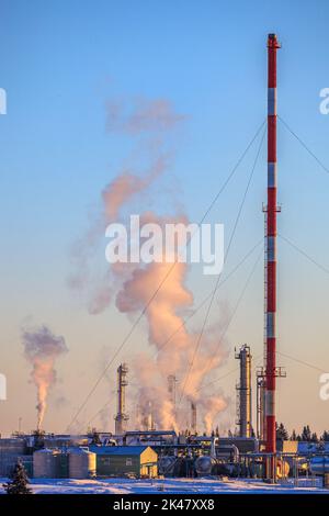 Dampf und andere Dämpfe werden an einem kalten Wintermorgen in einer Erdgasverarbeitungsanlage freigesetzt Stockfoto