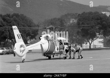 Die Auszubildenden steigen an Bord eines Aerospatiale Dauphin Hubschraubers, der von der Hongkonger Regierung der Flugdienste betrieben wird, und sind bereit für den Start an der Polizeischule in Hongkong 1984 Stockfoto