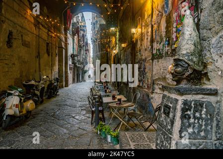 NEAPEL, ITALIEN - 2. JANUAR 2022: Enge Gassen des historischen Zentrums, die traditionelle Maske mit dem Gesicht von Pulcinella in der Altstadt von Neapel, Cam Stockfoto