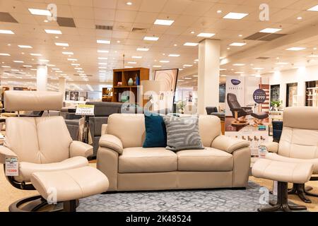 Harvey Norman Domayne Möbelgeschäft, stressfreier Ledersessel in beigem Leder mit Fußhocker, auch zweisitzige Sofa-Sofa, Sydney, Australien Stockfoto