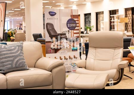 Harvey Norman Domayne Möbelgeschäft, stressfreier Ledersessel i beigefarbenes Leder mit Fußhocker, auch zwei-Sitzer-Sofa, Sydney, Australien Stockfoto