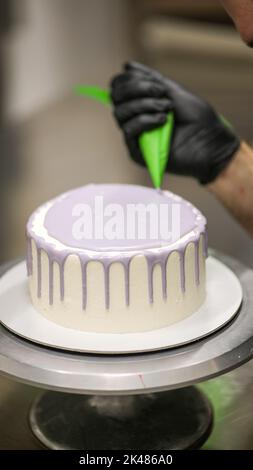 Koch mit Beutel dekorieren einen Milchkuchen Stockfoto
