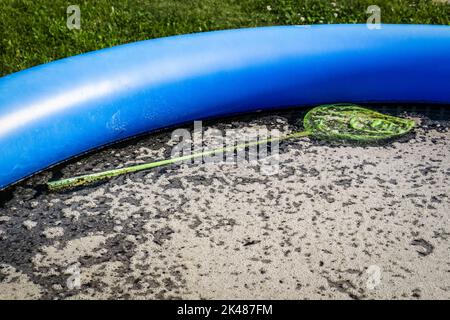 Schmutziges, stehendes Wasser in einem verlassenen, aufblasbaren Pool. Stockfoto