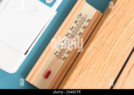 Haushaltsalkoholthermometer, das die Temperatur in Grad Celsius anzeigt, befindet sich an der blauen Wand, Nahaufnahme Stockfoto