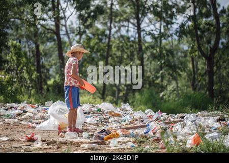 Ein armer Junge sammelt Müll von einer Deponie. Konzept des Lebensunterhalts armer Kinder.Kinderarbeit. Kinderarbeit, Menschenhandel, Armut Stockfoto