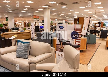 Harvey Norman Domayne Möbelgeschäft, stressfreier Ledersessel in beigem Leder mit Fußhocker, auch zweisitzige Sofa-Sofa, Sydney, Australien Stockfoto